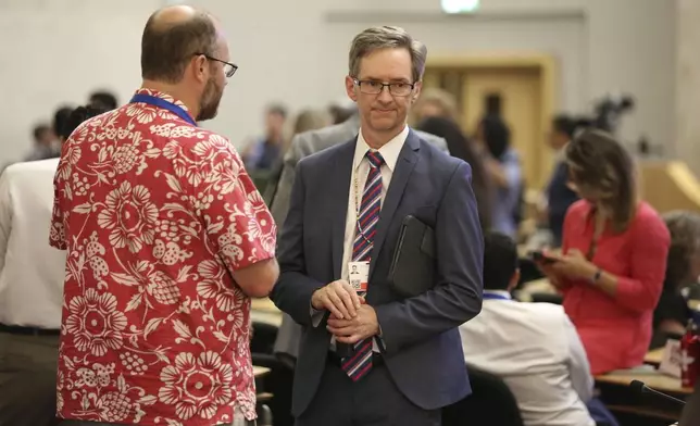 John Thompson, of the U.S. Department of State, right, speaks with Dennis Clare, legal advisor to Micronesia's delegation, after a meeting for delegates to the plastic pollution treaty talks in Geneva, Switzerland, convened and adjourned in less than a minute late on Thursday, August 14, 2025. (AP Photo/Jennifer McDermott)