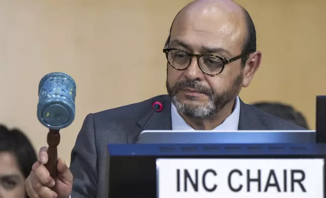 Luis Vayas Valdivieso, the chair of the negotiating committee, bangs a gavel made of recycled plastic bottle tops from a Nairobi landfill, during a plenary session of the second part of the fifth session of the Intergovernmental Negotiating Committee on Plastic Pollution, at the European headquarters of the United Nations in Geneva, Switzerland, Thursday, Aug. 14, 2025. (Martial Trezzini/Keystone via AP)