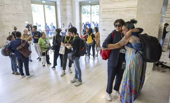 Members of the civil society embrace each other before leaving the second part of the fifth session of the Intergovernmental Negotiating Committee on Plastic Pollution, at the European headquarters of the United Nations in Geneva, Switzerland, Friday, Aug. 15, 2025. (Martial Trezzini/Keystone via AP)