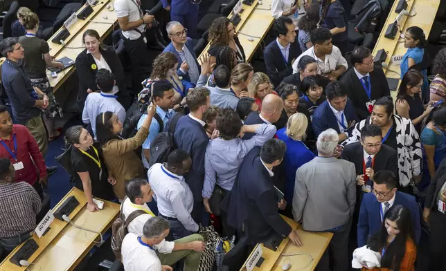 Delegates reacts during a plenary session of Second Part of the Fifth Session of the Intergovernmental Negotiating Committee on Plastic Pollution (INC-5.2), at the European headquarters of the United Nations in Geneva, Switzerland, Thursday, Aug. 14, 2025. (Martial Trezzini/Keystone via AP)