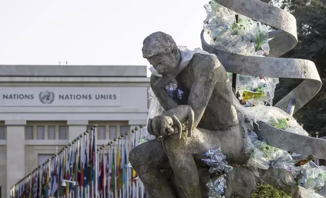 Plastic items are seen next to an artwork by Canadian artist and activist Benjamin Von Wong, titled "The Thinker's Burden", during the Fifth Session of the Intergovernmental Negotiating Committee on Plastic Pollution (INC-5.2), at the European headquarters of the United Nations in Geneva, Switzerland, Friday, August 15, 2025. (Martial Trezzini/Keystone via AP)