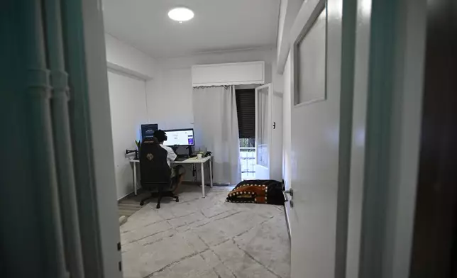 Murtaza Jafari, 25, an Afghan migrant, sits in front of his computer while teaching coding remotely to women currently living in Afghanistan, in Athens, Greece, Wednesday, July 23, 2025. (AP Photo/Michael Varaklas)