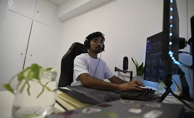 Murtaza Jafari, 25, an Afghan migrant, types code while teaching coding remotely to women currently living in Afghanistan, in Athens, Greece, Wednesday, July 23, 2025. (AP Photo/Michael Varaklas)