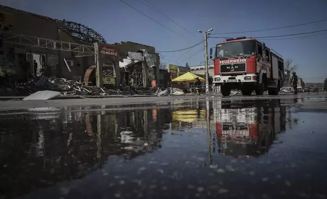 In this photo provided by Ukraine's 24th Mechanized Brigade press service, a firefighter puts out the fire after a Russian drone hit the market in the town of Druzhkivka, Donetsk region, Ukraine, Saturday, Aug. 2, 2025, (Oleg Petrasiuk/Ukraine's 24th Mechanized Brigade via AP)