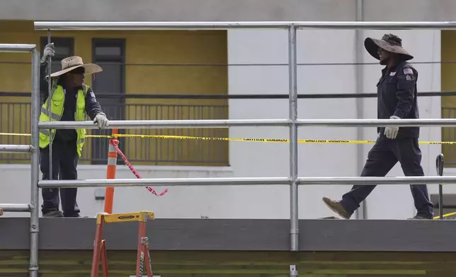 Construction crews work in the heat on Thursday, Aug. 21, 2025, in Los Angeles. (AP Photo/Damian Dovarganes)