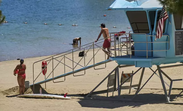 Los Angeles County lifeguards stand on guard as people cool off at Castaic Lake on Wednesday, Aug. 20, 2025, in Castaic, Calif. (AP Photo/Damian Dovarganes)