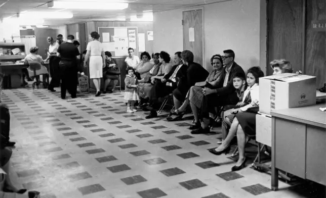 FILE - Cuban exiles wait for processing at the Cuban refugee center in Miami on April 12, 1963. (AP Photo, File)