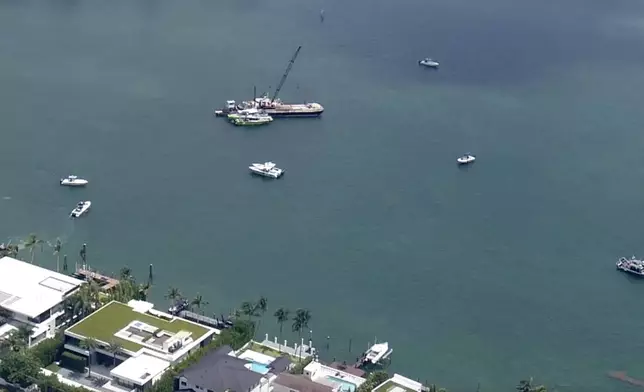 This image taken from video provided by WSVN-TV shows Miami-Dade Fire Rescue and others in boats around what appears to be a barge involved in an accident with a group of kids and an adult on a sailing boat during a sailing camp, Monday, July 28, 2025, in Miami. (WSVN-TV via AP)