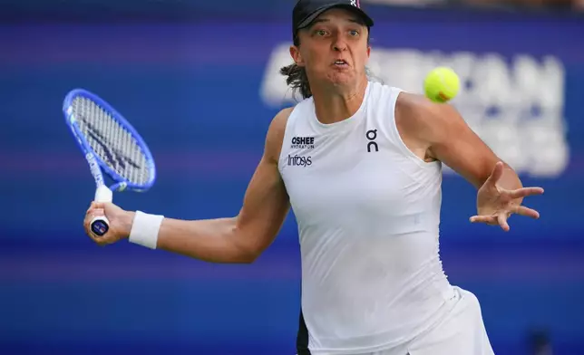 Iga Swiatek, of Poland, returns a shot to Emiliana Arango, of Colombia, during the first round of the US Open tennis championships, Tuesday, Aug. 26, 2025, in New York. (AP Photo/Yuki Iwamura)