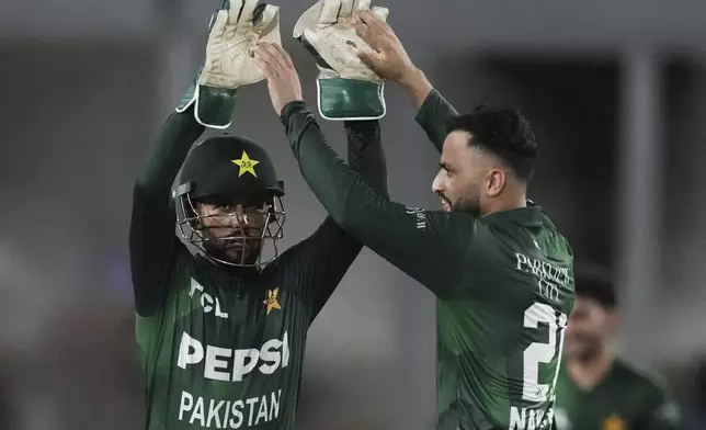 Pakistan's Mohammad Nawaz, right, celebrates with teammate after the dismissal of West Indies' Johnson Charles during the first Twenty20 cricket match between West Indies and Pakistan, in Lauderhill, Fla., Thursday, July 31, 2025. (AP Photo/Lynne Sladky)