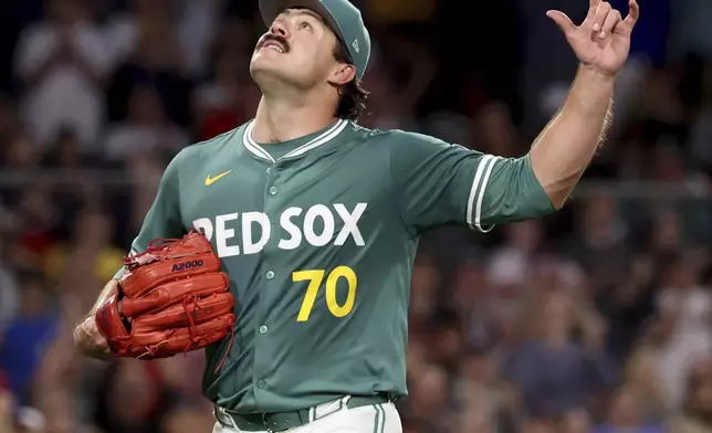 Boston Red Sox pitcher Payton Tolle gestures to the sky while walking to the dugout after being pulled during the sixth inning of a baseball game against the Pittsburgh Pirates, Friday, Aug. 29, 2025, in Boston. (AP Photo/Mark Stockwell)