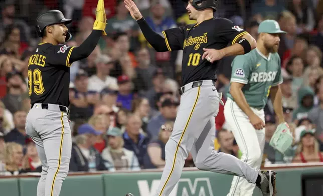 Pittsburgh Pirates Nick Gonzales (39) and Bryan Reynolds (10) high five at the plate after Reynolds hit a home run during the sixth inning of a baseball game against the Boston Red Sox, Friday, Aug. 29, 2025, in Boston. (AP Photo/Mark Stockwell)