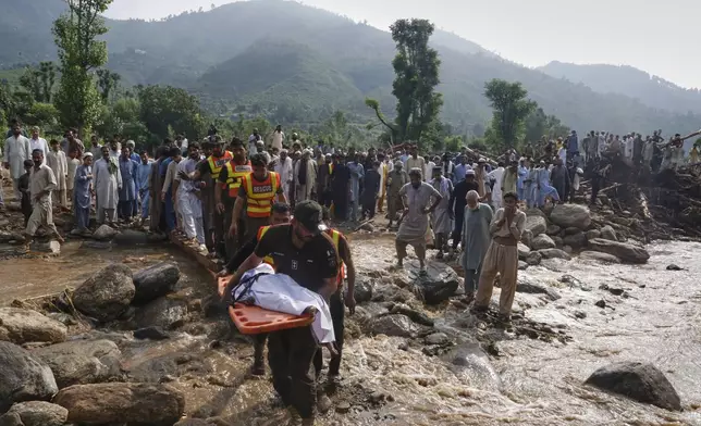 Rescue workers transport the body a victim of Friday's flash flooding after recovering it from the rubble of a damaged house at Qadir Nagar village near Pir Baba, Buner district, in Pakistan's northwest, Saturday, Aug. 16, 2025. (AP Photo/Muhammad Sajjad)