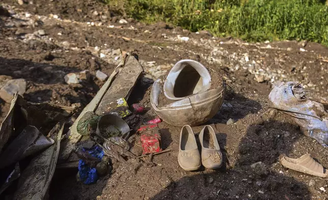 Shoes and other household items are seen on the debris of damaged houses at the incident site of cloudburst that triggered flash flood, in Naryan Behak village near Muzaffarabad, the main town of Pakistan's controlled Kashmir, Friday, Aug. 15, 2025. (AP Photo/M.D. Mughal)