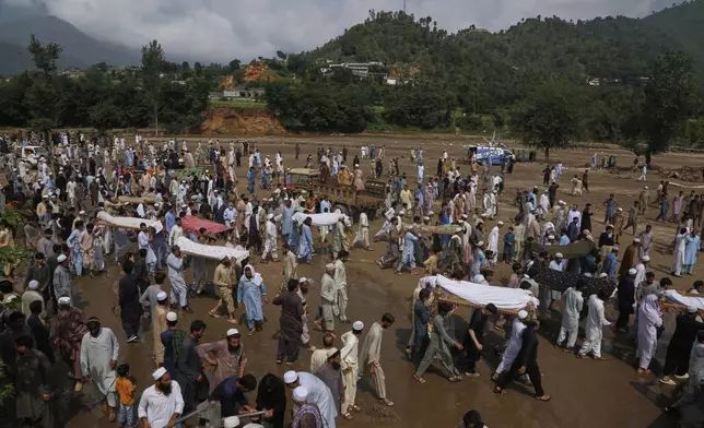 People carry bodies of the victims of Friday's flash flooding, after funeral prayers at a village near Pir Baba, Buner district, in Pakistan's northwest, Saturday, Aug. 16, 2025. (AP Photo/Muhammad Sajjad)