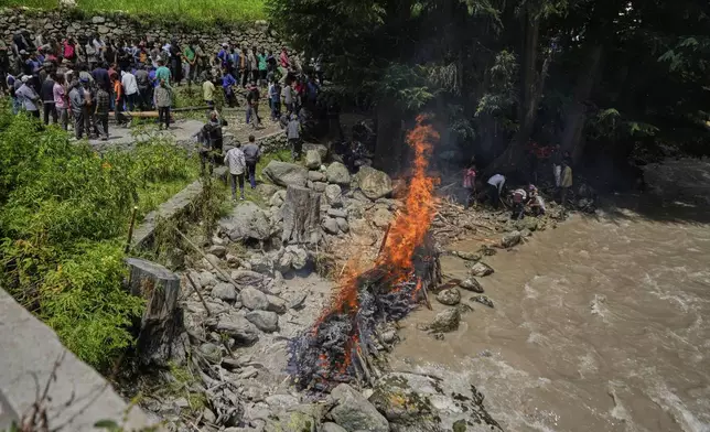 Villagers perform mass cremation of eight people died in a flash flood on the banks of the river Chenab in Chositi village, Kishtwar district, Indian-controlled Kashmir, Friday, Aug. 15, 2025. (AP Photo/Channi Anand)