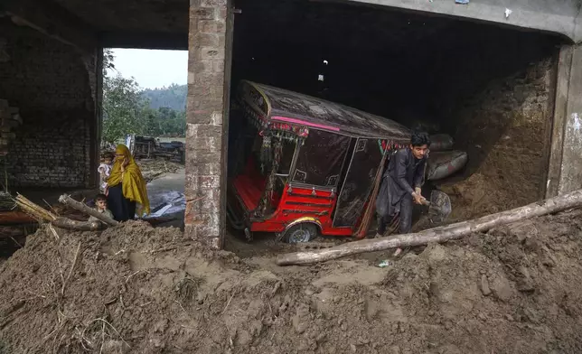 A local resident clears the debris and mud from a shop after Friday's flash flooding on the outskirts of Pir Baba, Buner district, in Pakistan's northwest, Saturday, Aug. 16, 2025. (AP Photo/Muhammad Sajjad)