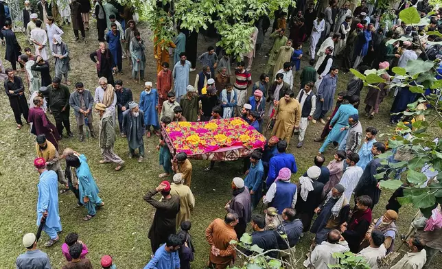 People carry a body a victim of a cloudburst incident, sudden intense downpours, after funeral prayers, in Naryan Behak village near Muzaffarabad, the main town of Pakistan's controlled Kashmir, Friday, Aug. 15, 2025. (AP Photo/M.D. Mughal)