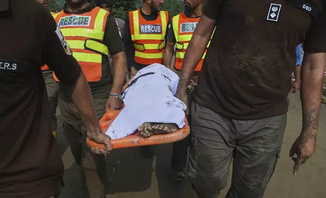 Rescue workers transport the body of a victim of Friday's flash flooding after recovering it from the rubble of a damaged house at Qadir Nagar village near Pir Baba, Buner district, in Pakistan's northwest, Saturday, Aug. 16, 2025. (AP Photo/Muhammad Sajjad)