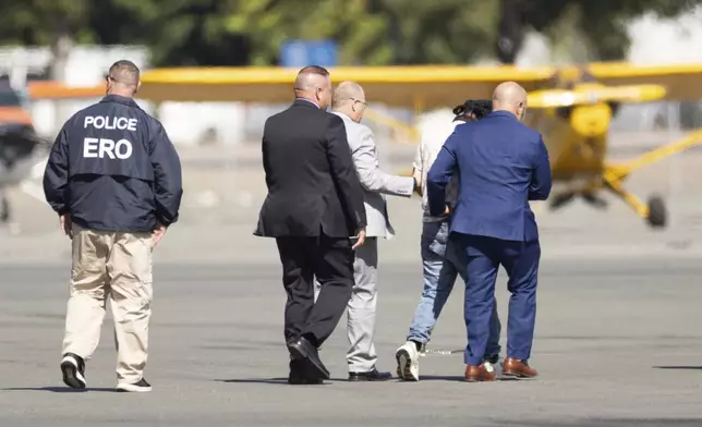 Harjinder Singh is escorted to an airplane by Florida Lt. Gov. Jay Collins and law enforcement on Thursday, Aug. 21, 2025, in Stockton, Calif. (AP Photo/Benjamin Fanjoy)