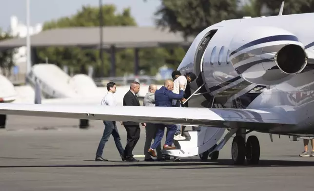 Harjinder Singh is escorted to an airplane by Florida Lt. Gov. Jay Collins and law enforcement on Thursday, Aug. 21, 2025, in Stockton, Calif. (AP Photo/Benjamin Fanjoy)