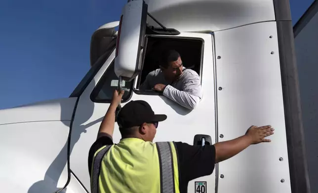 FILE - Senior instructor Markus Juarez, bottom, talks to student driver Jaime Rojas at California Truck Driving Academy in Inglewood, Calif., Wednesday, Nov. 17, 2021. (AP Photo/Jae C. Hong, File)
