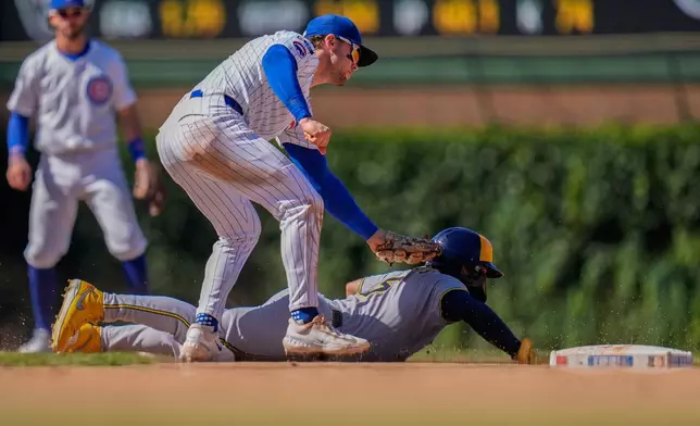 Chicago Cubs second baseman Nico Hoerner, top, catches Milwaukee Brewers' Isaac Collins, bottom, on a steal-attempt during the eighth inning of a baseball game Thursday, Aug. 21, 2025, in Chicago. (AP Photo/Erin Hooley)