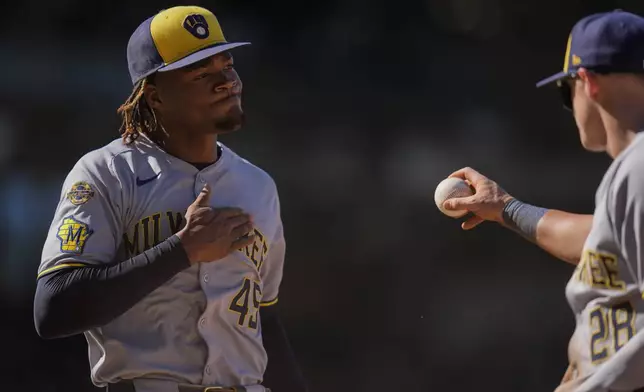 Milwaukee Brewers pitcher Abner Uribe, left, reacts after first baseman Andrew Vaughn (28) forced out Chicago Cubs' Owen Caissie to end the eighth inning of a baseball game Thursday, Aug. 21, 2025, in Chicago. (AP Photo/Erin Hooley)