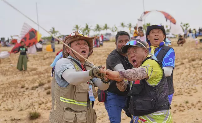 Participants from China pull the string of their kite during the Colombo International Kite Festival in Colombo, Sri Lanka, Saturday, Aug. 23, 2025. (AP Photo/Eranga Jayawardena)