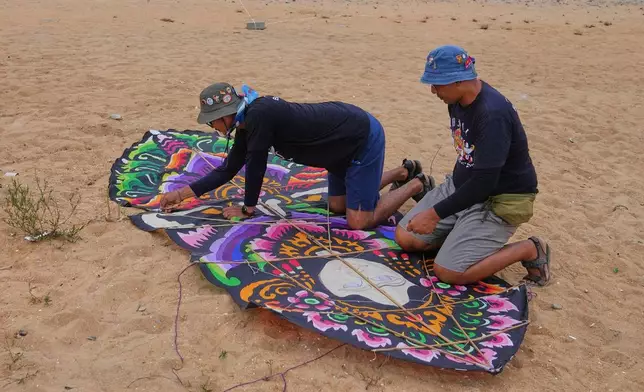 Participants prepare a kite to fly during the Colombo International Kite Festival in Colombo, Sri Lanka, Saturday, Aug. 23, 2025. (AP Photo/Eranga Jayawardena)