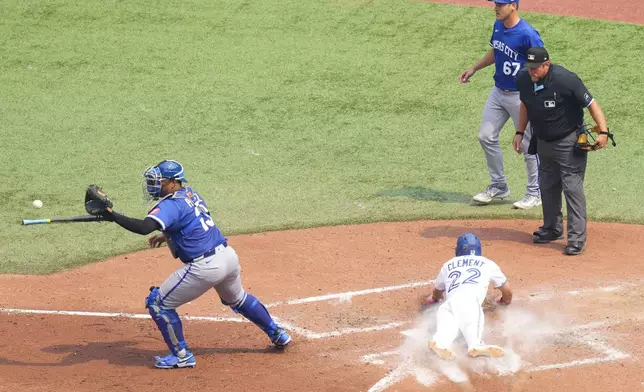 Toronto Blue Jays' Ernie Clement (22) scores in front of Kansas City Royals catcher Salvador Perez after a RBI single from Joey Loperfido during the fifth inning of a baseball game in Toronto on Sunday Aug. 3, 2025. (Chris Young/The Canadian Press via AP)