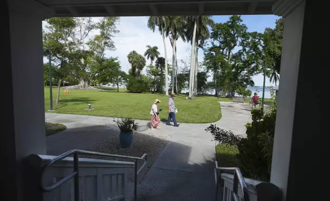 Visitors walk on the property of the Edison and Ford Winter Estates, Saturday, Aug. 9, 2025, in Fort Myers, Fla., which date from 1885, when Edison purchased the property to build a vacation home. (AP Photo/Lynne Sladky)