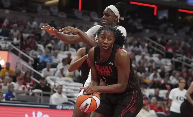 Indiana Fever forward Aliyah Boston grabs a rebound from Seattle Storm center Dominique Malonga during the first half of a WNBA basketball game, Tuesday, Aug. 26, 2025, in Indianapolis. (AP Photo/Darron Cummings)