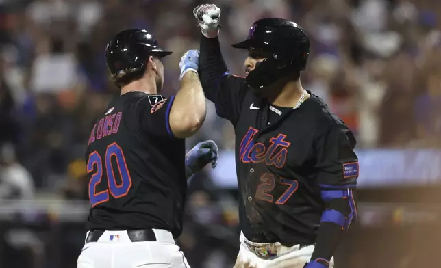 New York Mets' Pete Alonso, left, and Mark Vientos, right, react after Alonso hit a two-run home run which also scored Juan Soto during the second inning of a baseball game against the Miami Marlins, Friday, Aug. 29, 2025, in New York. (AP Photo/Pamela Smith)
