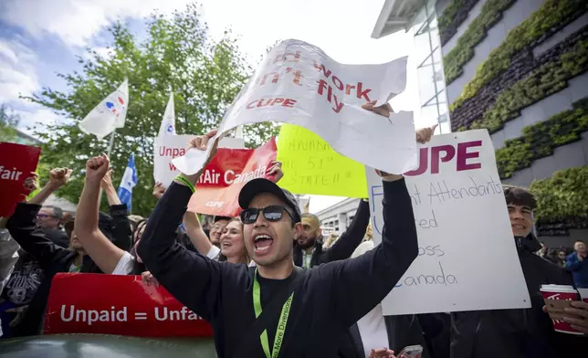 Picketers cheer as they hear news that Air Canada has halted a restart of operations at the Vancouver International Airport in Richmond, B.C., on Sunday, Aug. 17, 2025. (Ethan Cairns/The Canadian Press via AP)