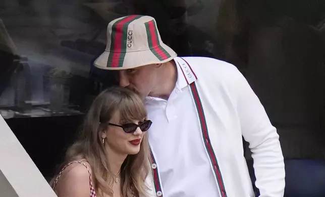 FILE - Taylor Swift gets a kiss from Kansas City Chiefs tight end Travis Kelce as they arrive to watch play between Jannik Sinner, of Italy, and Taylor Fritz, of the United States, during the men's singles final of the U.S. Open tennis championships, Sept. 8, 2024, in New York. (AP Photo/Frank Franklin II, File)