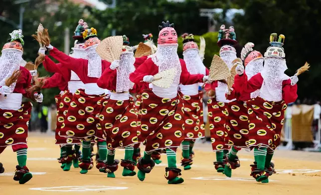 People dressed in costumes perform during the mask festival in Porto-Novo, Benin , Sunday, Aug. 3, 2025. (AP Photo/Sunday Alamba)