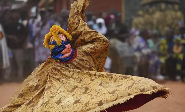 People dressed in costumes dance during a mask festival in Porto Novo, Benin , Saturday, Aug. 2, 2025. (AP Photo/Sunday Alamba)