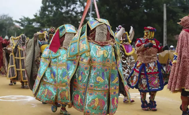 People dressed in costumes perform during the mask festival in Porto-Novo, Benin , Sunday, Aug. 3, 2025. (AP Photo/Sunday Alamba)