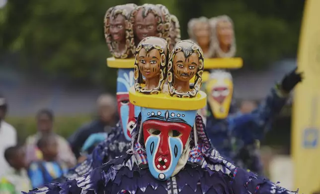 People dress in costumes perform during the mask festival in Porto-Novo, Benin , Sunday, Aug. 3, 2025. (AP Photo/Sunday Alamba)