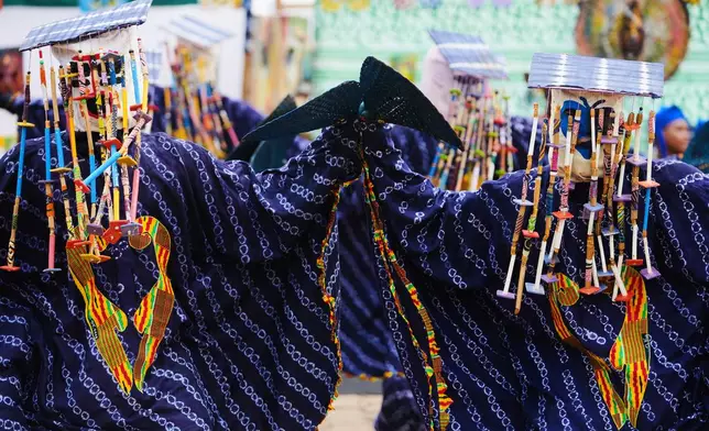 People dressed in costumes perform during the mask festival in Porto-Novo, Benin , Sunday, Aug. 3, 2025. (AP Photo/Sunday Alamba)