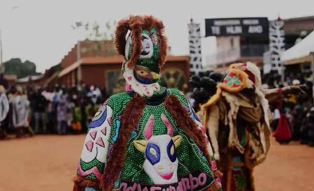 People dress in costumes and dance during a mask festival in Porto Novo, Benin , Saturday, Aug. 2, 2025. (AP Photo/Sunday Alamba)