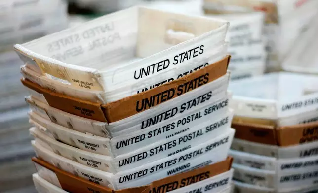 FILE- In this Dec. 14, 2017, file photo, boxes for sorted mail are stacked at the main post office in Omaha, Neb. (AP Photo/Nati Harnik, File)