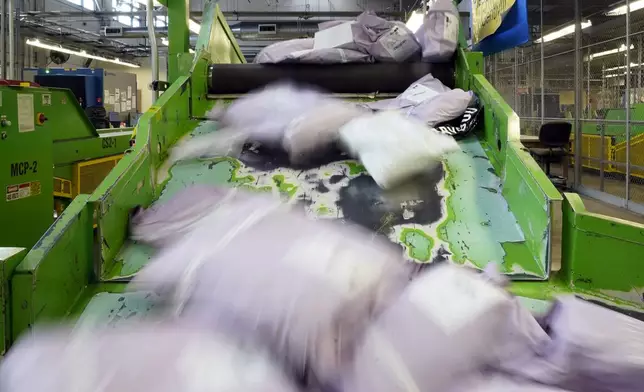 FILE - Parcels slide down a ramp after being scanned at the U.S. Customs and Border Protection overseas mail inspection facility at Chicago's O'Hare International Airport Feb. 23, 2024, in Chicago. (AP Photo/Charles Rex Arbogast, File)