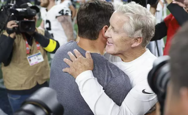 Seattle Seahawks head coach Mike Macdonald, left, hugs Las Vegas Raiders head coach Pete Carroll after an NFL preseason football game Thursday, Aug. 7, 2025, in Seattle. (AP Photo/Maddy Grassy)
