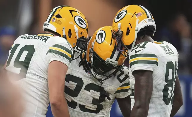 Green Bay Packers running back Israel Abanikanda (23) celebrates a touchdown with quarterback Taylor Elgersma (19) and wide receiver Julian Hicks (81) during the second half of a preseason NFL football game, Saturday, Aug. 16, 2025, in Indianapolis. (AP Photo/Michael Conroy)