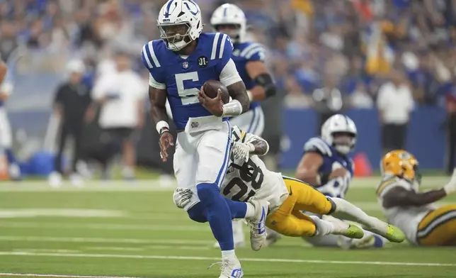 Indianapolis Colts quarterback Anthony Richardson Sr. (5) is tackled by Green Bay Packers linebacker Isaiah Simmons (28) during the first half of a preseason NFL football game, Saturday, Aug. 16, 2025, in Indianapolis. (AP Photo/Michael Conroy)