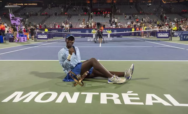 Victoria Mboko, of Canada, poses with the trophy after her win over Naomi Osaka, of Japan, in final action at the National Bank Open women's tennis tournament in Montreal, Thursday, Aug. 7, 2025. (Christinne Muschi/The Canadian Press via AP)