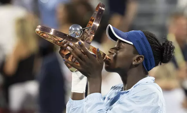 Victoria Mboko of Canada kisses the trophy following her win over Naomi Osaka of Japan during finals tennis action at the National Bank Open in Montreal, Thursday, Aug. 7, 2025. (Christinne Muschi/The Canadian Press via AP)