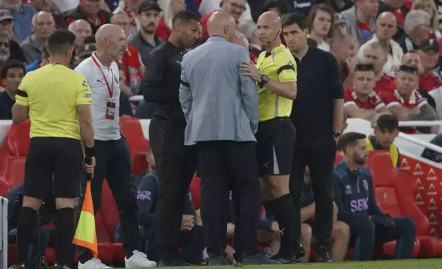 Liverpool's manager Arne Slot, centre, talks to the referee during the English Premier League soccer match between Liverpool and Bournemouth at Anfield stadium in Liverpool, England, Friday, Aug. 15, 2025. (AP Photo/Ian Hodgson)